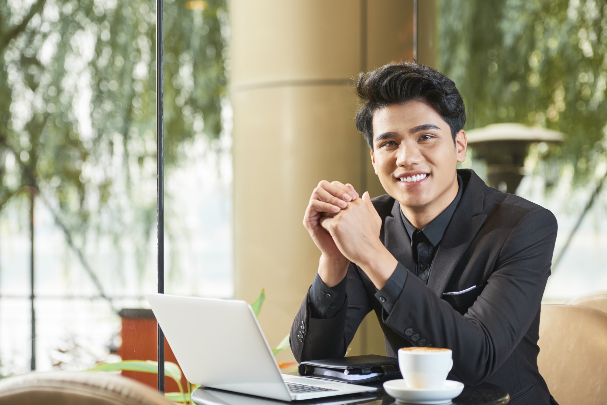 Cheerful Asian Businessman In Cafe